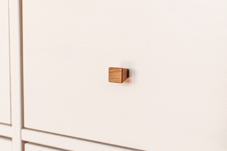 May include: A white drawer with a square wooden knob.