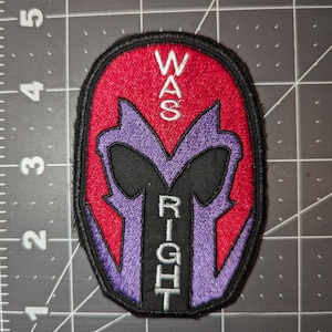 Peut inclure: Un patch brod&eacute; repr&eacute;sentant une silhouette violette et noire du casque de Magneto avec les mots "WAS RIGHT" en texte blanc.