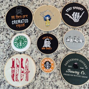 May include: A collection of embroidered hoops with Halloween and witch-themed designs. The hoops feature phrases like "Stay Spooky" and "Sanderson Sisters Brewing Co." along with spooky graphics and a Starbucks-inspired design.