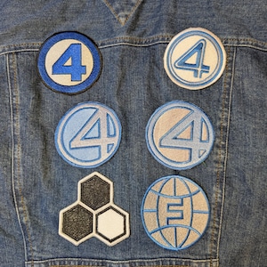 May include: A denim jacket with several embroidered patches. The patches feature the number "4" in various designs, along with a honeycomb and a globe with the letter "E". The patches are in shades of blue, white, and gray.