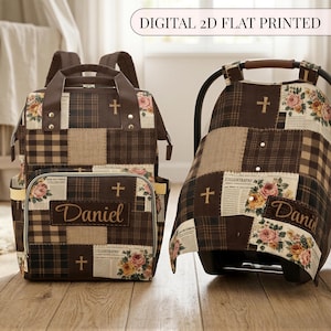 May include: A brown patchwork diaper backpack and a matching infant car seat cover featuring a print of crosses, floral bouquets, and newspaper text. Both items are personalized with the name Daniel in a script font on a rectangular patch.