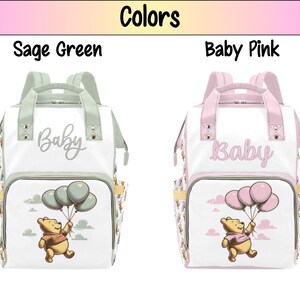 May include: Two Winnie the Pooh diaper bags, one in sage green and one in baby pink. Both bags feature a white background with a Winnie the Pooh illustration holding balloons and the word "Baby" in a script font.