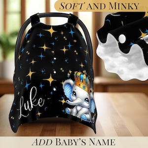 Könnte beinhalten: Eine schwarze Baby-Autositzabdeckung mit einem Muster aus goldenen und blauen Sternen. Die Abdeckung zeigt einen Cartoon-Elefanten mit Krone und dem Namen "Luke" in weißer Schrift. Der Text "Soft and Minky" und "Add Baby's Name" sind ebenfalls sichtbar.