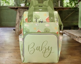 May include: Green and brown baby diaper bag backpack with a farm animal print and the word "Baby" on the front.