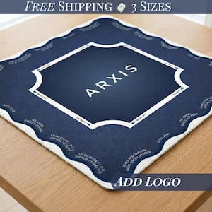 May include: A navy blue and white playing mat with the word "ARXIS" in the center. The mat has a white border and text around the edges, including "Charleston" and "No Jokers". The mat is on a wooden table.