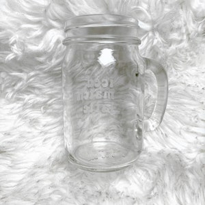 May include: A clear glass mason jar mug with a handle. The jar has the words "Best Mom Ever" etched into the side.