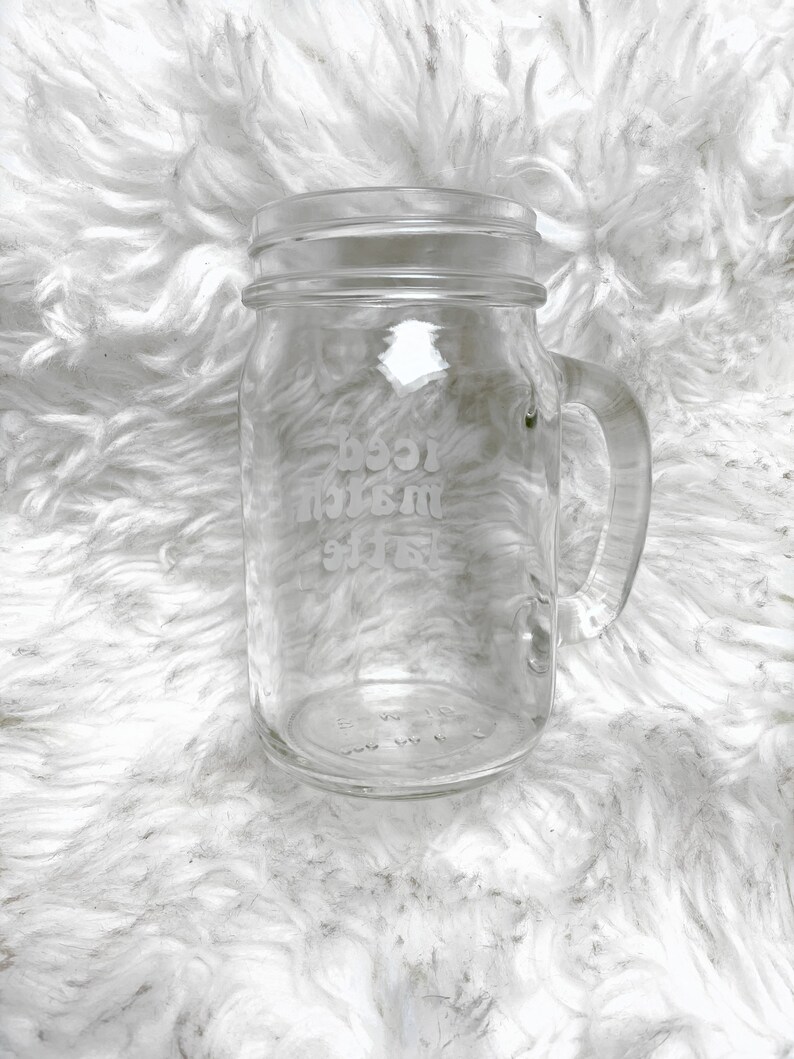 May include: A clear glass mason jar mug with a handle. The jar has the words "Best Mom Ever" etched into the side.