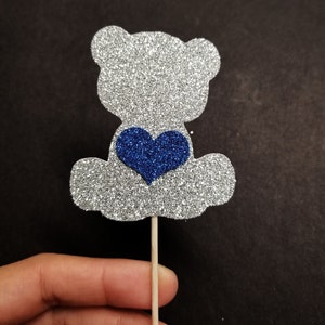 May include: Silver glitter bear cupcake topper with a blue glitter heart.