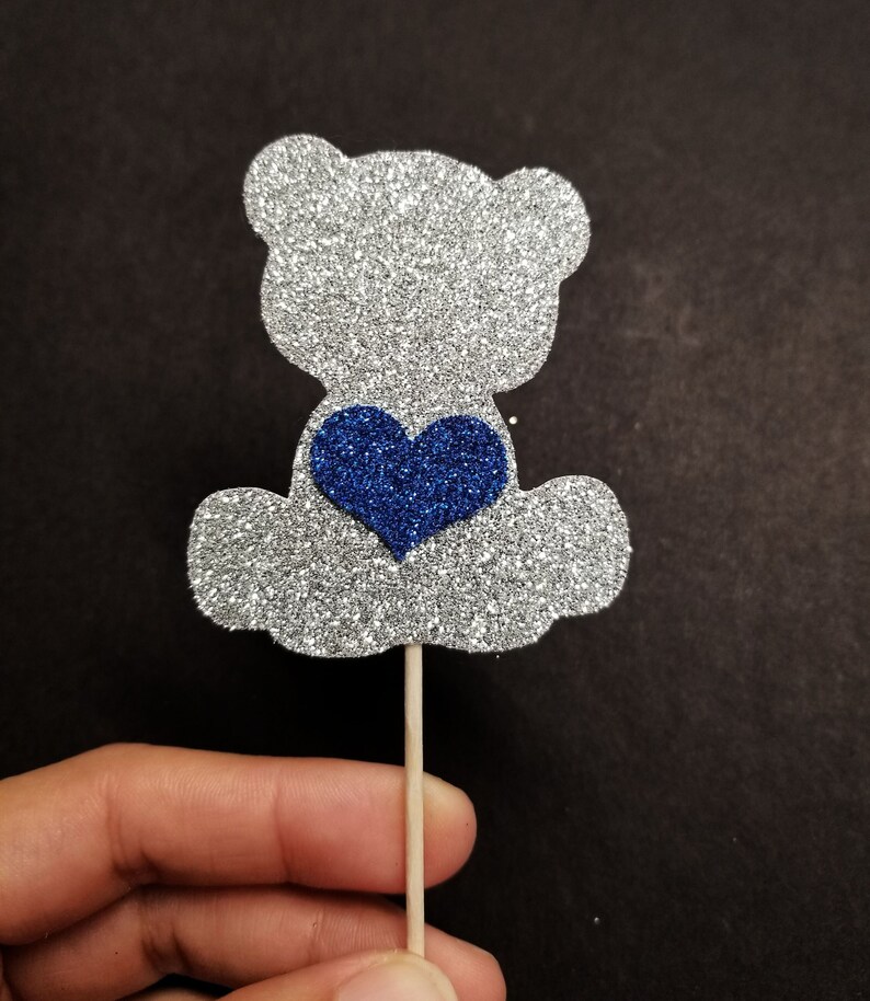May include: Silver glitter bear cupcake topper with a blue glitter heart.
