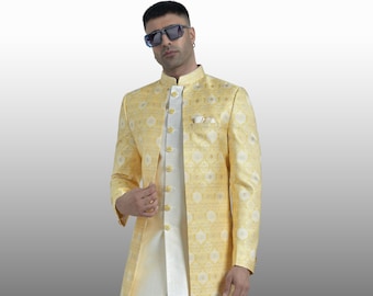 Könnte beinhalten: Eine gelbe, gemusterte Jacke mit langen Ärmeln, einem Stehkragen und einer weißen Hose. Die Jacke hat ein weißes Futter und goldene Knöpfe. Die Person trägt weiße Schuhe.