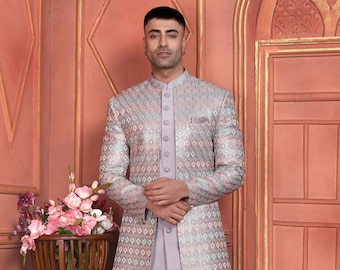May include: A light purple long jacket with a geometric pattern in shades of pink, blue, and white. The jacket has a mandarin collar and a button closure. The model is wearing matching light gray pants and white shoes.