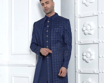 Könnte beinhalten: Eine marineblaue, langärmelige Kurta mit gemustertem Design und goldenen Knöpfen. Die Kurta wird mit einer passenden marineblauen Hose und schwarzen Slipper kombiniert. D.NO. 2770