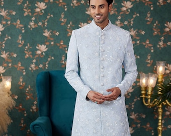 May include: A light blue embroidered kurta with a white collar and white pants. The kurta has a button closure and is decorated with sequins.