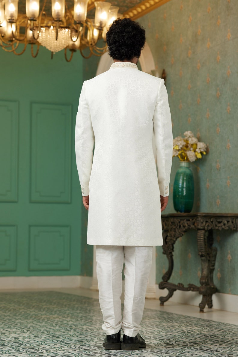 Puede incluir: Una kurta blanca de manga larga con un sutil estampado floral. La kurta tiene un cuello mandar&iacute;n y se lleva con pantalones blancos.