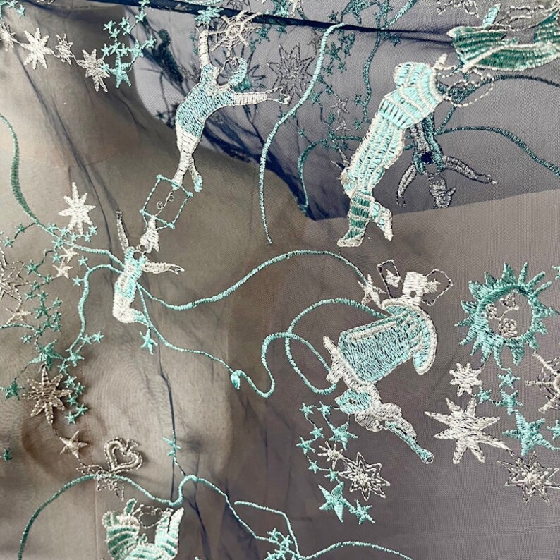 May include: Black sheer fabric with a teal and silver embroidered design of stars and whimsical figures.