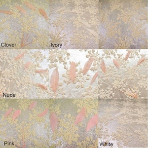 May include: A collage of five different colored feathers on a white background with a floral pattern. The colors are clover, ivory, nude, pink, and white.