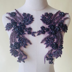 May include: Two purple beaded appliques with a floral design. The appliques are made of small beads and sequins and are perfect for adding a touch of sparkle to any project.