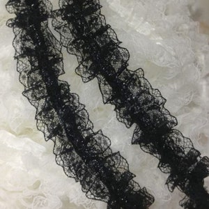 May include: Two pieces of black ruffled lace trim with a sparkly finish.
