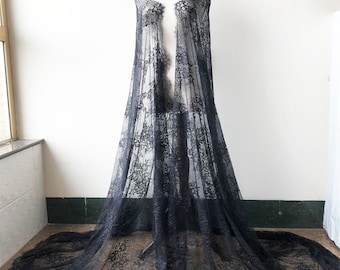 May include: Black lace fabric with a delicate floral pattern. The fabric is sheer and has a soft, flowing drape.