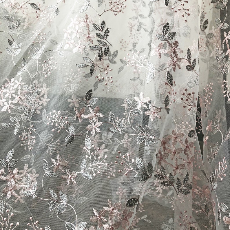 May include: White tulle fabric with a delicate floral embroidery pattern in silver and pink.