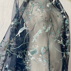 May include: Navy blue sheer fabric with silver and green embroidered stars, moons, and whimsical creatures.