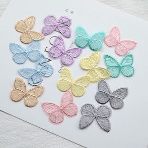 May include: Assortment of 12 delicate lace butterfly appliques in various pastel colors, including pink, blue, yellow, and purple. These decorative embellishments are perfect for adding a touch of whimsy to crafts, clothing, and home decor.