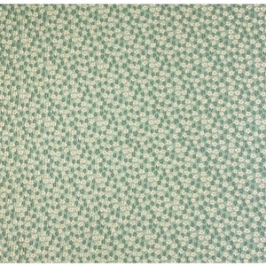 May include: A green fabric with a white floral pattern. The fabric is covered in small white flowers.