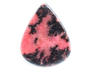 Puede incluir: Una gema en forma de lágrima con superficie pulida. La piedra presenta un llamativo patrón de rosa y negro, con el rosa como color base y el negro creando una red de formas irregulares en la superficie.