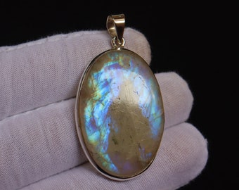 May include: Oval-shaped pendant with a silver setting and a large iridescent gemstone with blue, green, and purple hues.