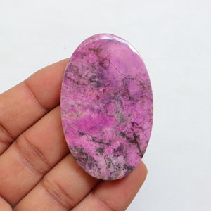 May include: A pink and gray oval cabochon gemstone with a marbled pattern.