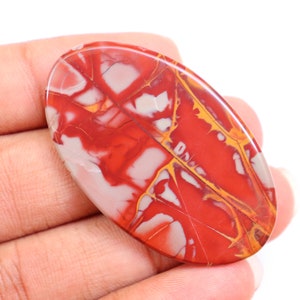 May include: A red, white, and yellow oval-shaped stone with a marbled pattern.