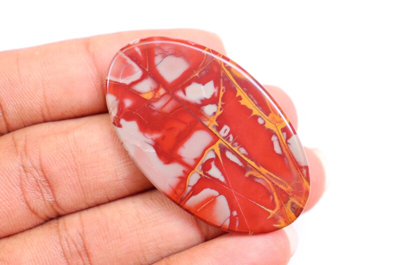 May include: A red, white, and yellow oval-shaped stone with a marbled pattern.