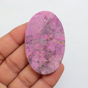 May include: A pink and gray oval cabochon gemstone with a marbled pattern.