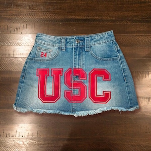 May include: A blue denim skirt with a red "USC" logo and the number "24" on the front.