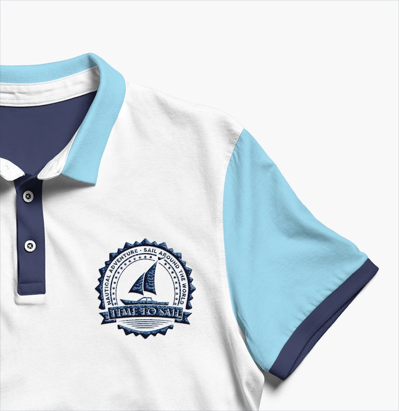 May include: White polo shirt with a blue and light blue color block design. The shirt has a navy blue collar and a navy blue embroidered patch on the left chest that says "Nautical Adventure - Sail Around The World - Time To Sail".