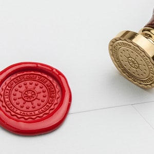 May include: A red wax seal with the text "East Coast Yacht Club Explore the World" and a nautical wheel design.