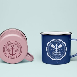 May include: Two enamel mugs with nautical designs. The pink mug has a white anchor and the text "Offshore Sailing Team". The blue mug has a white anchor and paddles with the text "Ocean Adventure".