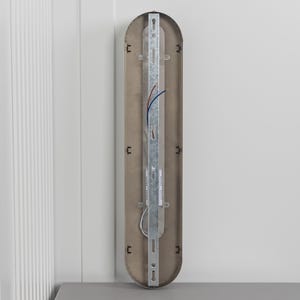 May include: A vertical, pill-shaped light fixture backplate with a metallic finish. It features a central galvanized steel mounting bracket, exposed electrical wiring in blue and red, and small black plastic clips along the inner edges for assembly.