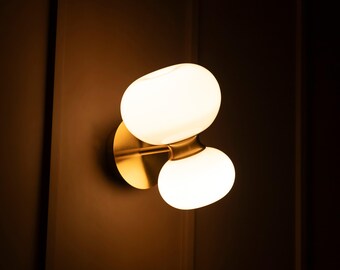 Modern Glass Wall Sconce: Aged Metal Frame & Soft Globe Light