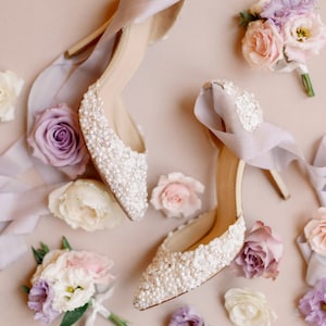 Bridal shoe with ivory pearl and floral detail and a high heel and  ribbon ankle ties