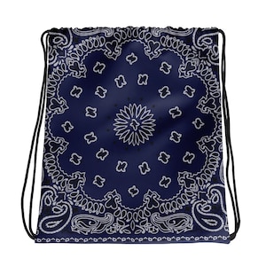 May include: A navy blue drawstring bag with a white bandana pattern. The bag has a white and black paisley design in the center.
