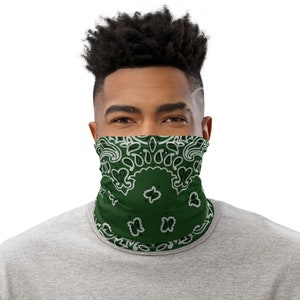 May include: A green face mask with a white paisley pattern. The mask is made of a soft, breathable fabric and is designed to be comfortable to wear.