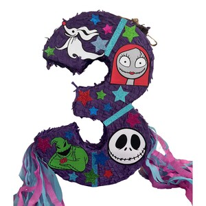 Puede incluir: Una pi&ntilde;ata con forma de n&uacute;mero tres de color morado decorada con estrellas brillantes en azul, verde y rosa. Presenta recortes de personajes de un perro fantasma blanco, una figura femenina de piel p&aacute;lida con pelo rojo y una calavera blanca.