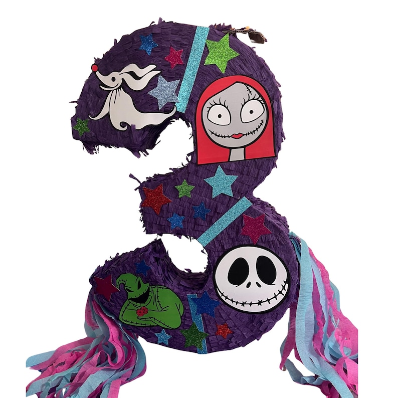 Puede incluir: Una pi&ntilde;ata con forma de n&uacute;mero tres de color morado decorada con estrellas brillantes y recortes de personajes que incluyen un perro fantasma blanco, una figura de pelo rojo, una criatura verde y una calavera blanca con tiras de papel.