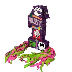 Puede incluir: Una pi&ntilde;ata con forma de n&uacute;mero uno en color morado, decorada con el nombre Arleth en purpurina rosa, con recortes de Zero, Sally, Oogie Boogie y Jack Skellington, acentuada con estrellas coloridas y largas tiras de papel rosa y verde.