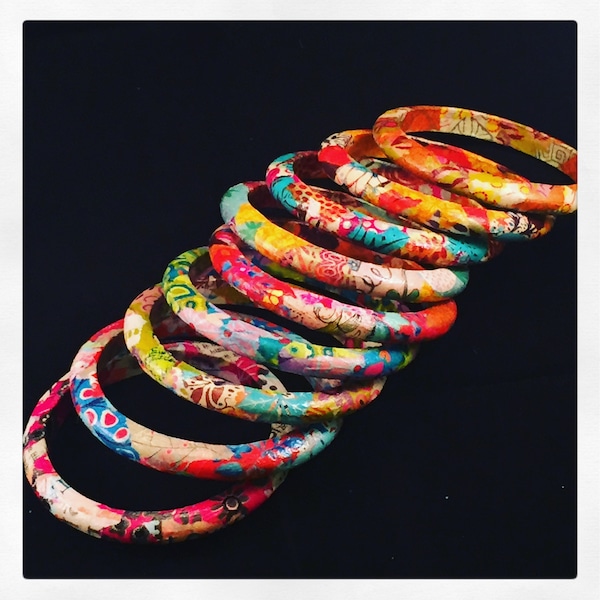 Unique costume jewelry, colorful bracelets made with tissue paper on wooden support, artisanal creation