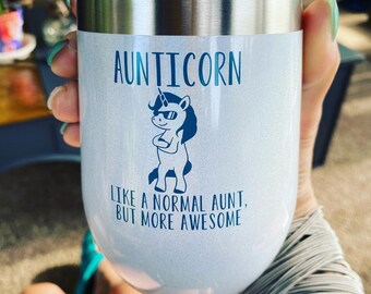 Könnte beinhalten: Ein Edelstahlbecher mit weißer, glitzernder Oberfläche. Er zeigt eine blaue Einhorn-Grafik mit dem Text "Aunticorn, wie eine normale Tante, aber viel cooler".
