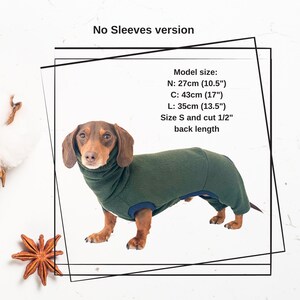 May include: A dachshund wearing a green and blue fleece dog sweater with no sleeves. The sweater has a turtleneck collar. The dog is standing on a white surface. The text "No Sleeves version" is at the top of the image. The text "Model size: N: 27cm (10.5") C: 43cm (17") L: 35cm (13.5") Size S and cut 1/2" back length" is in the bottom right corner of the image.