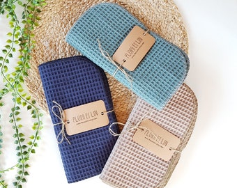 May include: Three waffle weave kitchen towels in blue, beige, and green with a brown tag that reads "Florr El Lin" and the website address.
