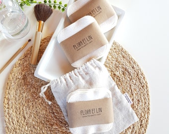 May include: Three white reusable makeup remover pads with brown paper labels that say "Flora et Lin" and "www.floraetlin.com". The pads are on a white plate and a woven straw placemat.